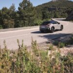 Lexus RZ visto desde atrás en carretera con conducción dinámica.