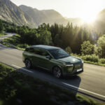 Lexus TZ verde circulando por una carretera de montaña al amanecer.