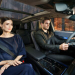 Pareja viajando en el interior del Lexus TZ con iluminación ambiental azul.