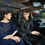 Pareja conversando en el interior del Lexus TZ durante un trayecto urbano.